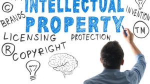 Man writing on whiteboard the words "Intellectual Property" with associated terms around it