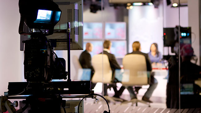 Monitor in focus and broadcast newsroom in background