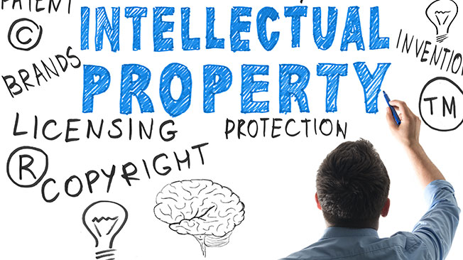 Man writing on whiteboard with words "Intellectual Property", "Licensing", and more copyright terms.