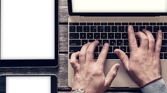 Register-for-royalties-FI Hands typing on a laptop keyboard
