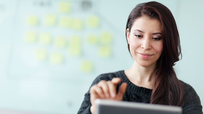 Registration-Options-FI Woman looking at screen with finger ready to make a selection