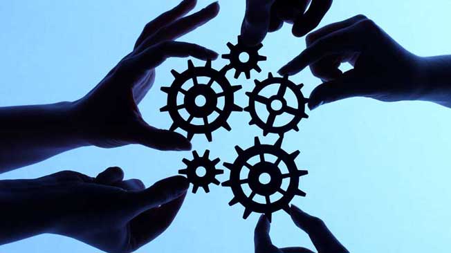 Collaboration graphic - cogs being placed next to each other by hands