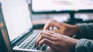 hands typing on laptop keyboard