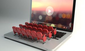 laptop computer with video on screen and cinema style seating popping up from keyboard
